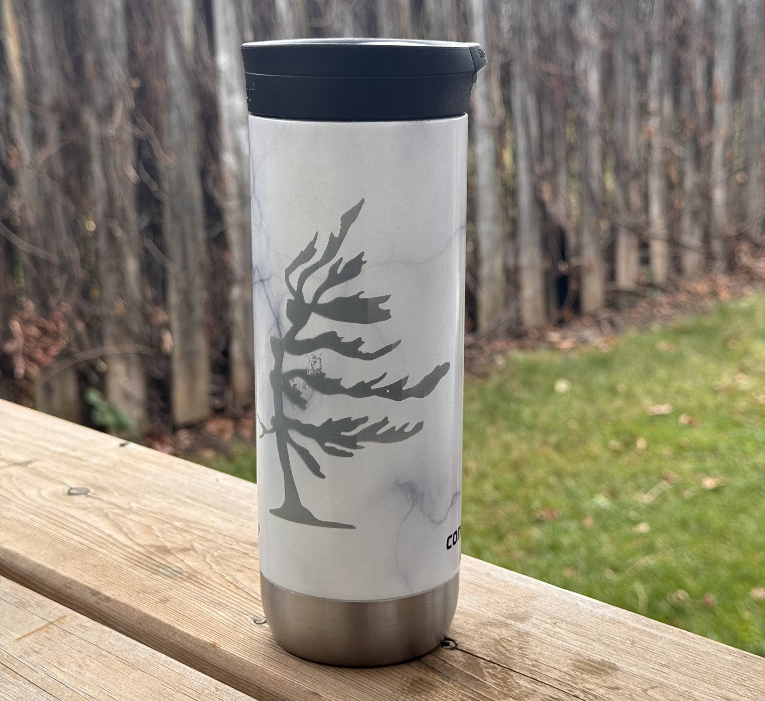 White insulated tumbler with an engraved dragon design