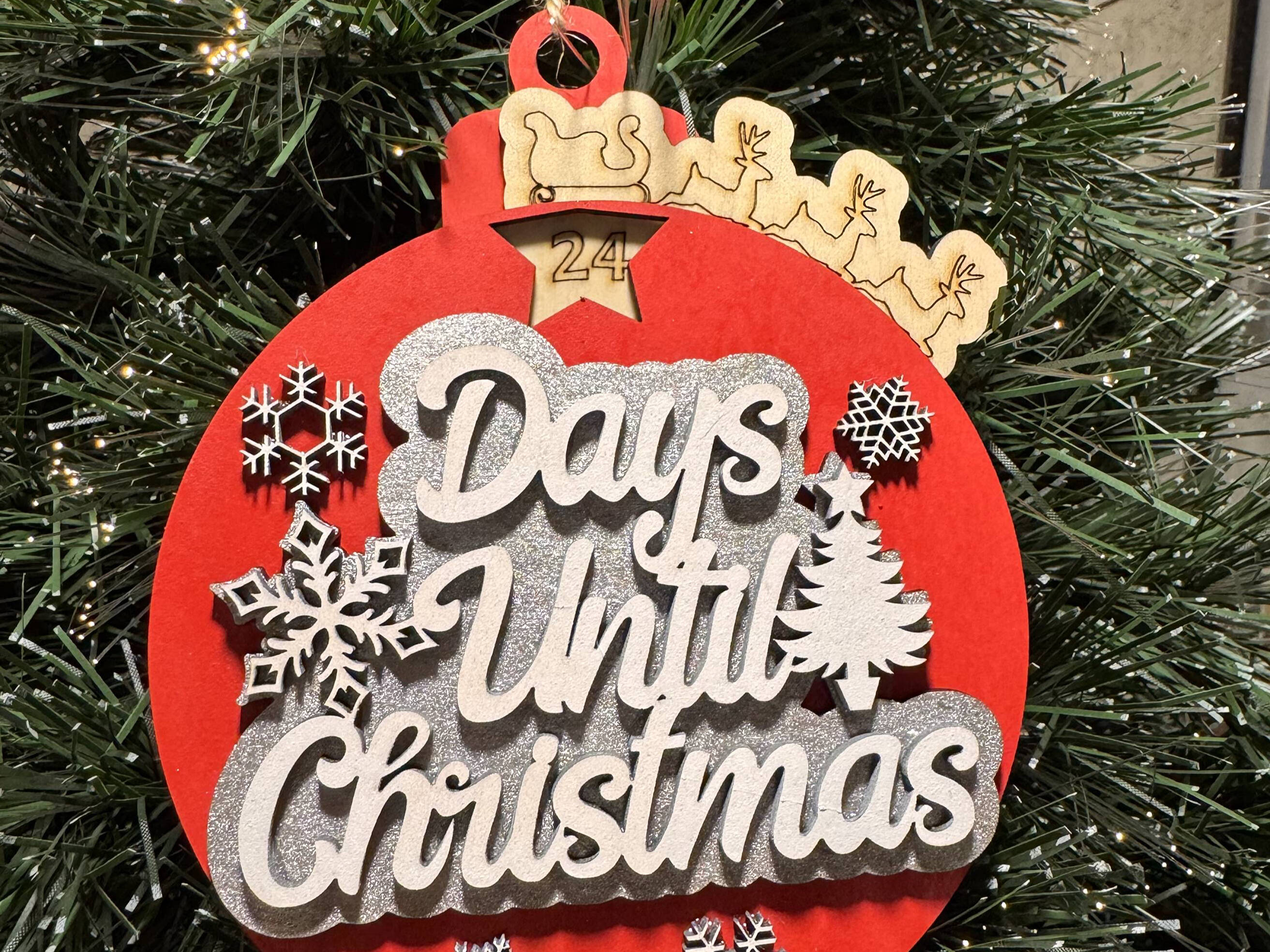 Red and wood Days Until Christmas ornament on a tree